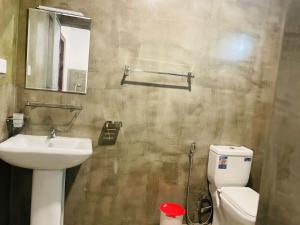un bagno con lavandino, WC e specchio di Abhi Villa ad Ahangama
