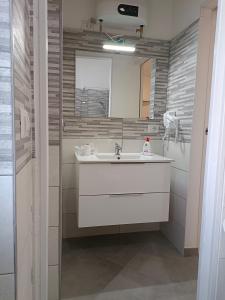 um banheiro com uma pia branca e um chuveiro em Orchidea Home em Busto Arsizio
