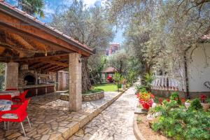 a stone patio with red chairs and a pavilion at President Bungalows and Apartments in Utjeha