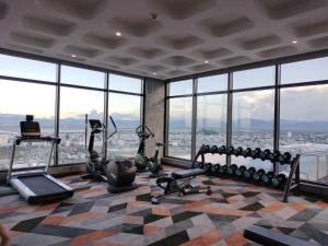 a gym with gym equipment in a building with windows at Wins House - Apec Mandala Phú Yên in Tuy Hoa