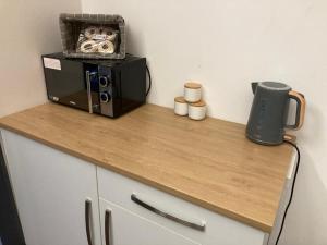 a counter with a microwave on top of a table at The Bolt Hole - Looe. in Looe
