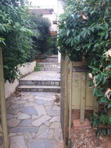 uma entrada para um jardim com escadas e plantas em Athens The View em Atenas