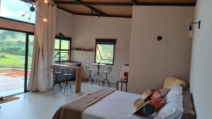 a bedroom with a bed and a table and chairs at Chalés do Mato Dentro in Paraisópolis