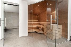 a sauna with wooden walls and a glass door at A CASA Serenity in Serfaus