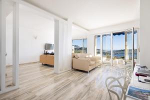 a living room with white walls and floor to ceiling windows at Luxury Top Floor Sea View Apartment in Villefranche sur Mer in Villefranche-sur-Mer