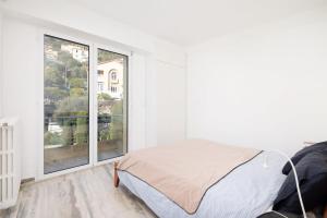 a bedroom with a bed and a large window at Luxury Top Floor Sea View Apartment in Villefranche sur Mer in Villefranche-sur-Mer
