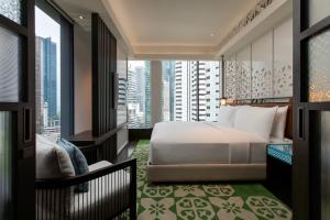 Hotel Indigo Kuala Lumpur on the Park, an IHG Hotel في كوالالمبور: غرفة نوم بسرير وإطلالة على مدينة