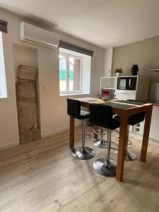 a room with a desk with a computer and chairs at L'appartement charmant in Beynost