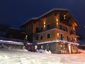 ein beleuchtetes Gebäude im Schnee in der Unterkunft Maison Constance in Bionaz