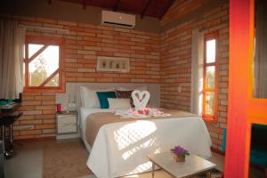 - une chambre avec un lit dans un mur en briques dans l'établissement Pousada Mirante dos Canyons, à Praia Grande