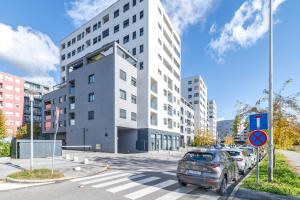ザグレブにあるLILY apartment - Flexible SelfCheckins 48- Luxury- Extra big terrace with jacuzziの白い建物の前に停車する車
