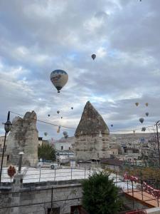 a bunch of hot air balloons flying in the sky at Century Cave Hotel in Göreme