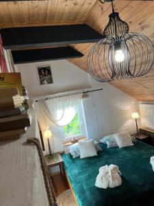 Un dormitorio con una cama verde y una lámpara de araña. en Bonaluti, en Mirsk