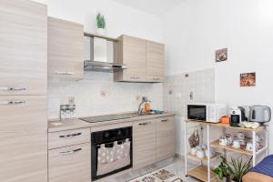 cocina con armarios de madera y horno con fogones en [10 min Torino] Moderna Casa Due Piani con Cortile, en Moncalieri