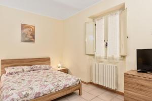 1 dormitorio con 1 cama y TV de pantalla plana en [10 min Torino] Moderna Casa Due Piani con Cortile, en Moncalieri
