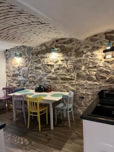 a kitchen with a table and chairs and a stone wall at Bonaluti Adults - Azyl Dla Dorosłych in Mirsk