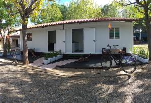 una bicicleta estacionada frente a una casa blanca en Camping las Catalinas, en Riolobos