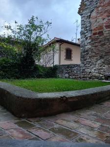 un mur en pierre à côté d'un bâtiment avec une cour dans l'établissement Casa vacanza Raffaela, à Gubbio