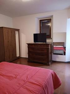 - une chambre avec un lit et une télévision sur une commode dans l'établissement Casa vacanza Raffaela, à Gubbio