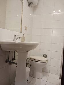 biała łazienka z umywalką i toaletą w obiekcie Casa vacanza Raffaela w mieście Gubbio