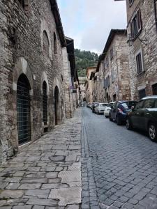 a cobblestone street with cars parked next to buildings at Casa vacanza Raffaela in Gubbio