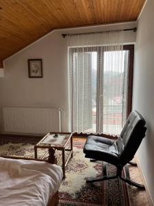 um quarto com uma cadeira, uma mesa e uma janela em Zelena Oaza Krupanj em Krupanj