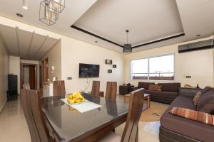 a living room with a table and a couch at Appartement en résidence avec piscine in Agadir