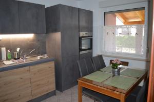 una pequeña cocina con mesa y fregadero en Apartma Patrik en Kobarid