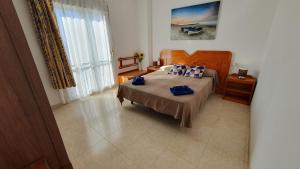 sypialnia z łóżkiem z niebieskimi poduszkami w obiekcie Rico Apartaments Ricosol w mieście Torrox Costa