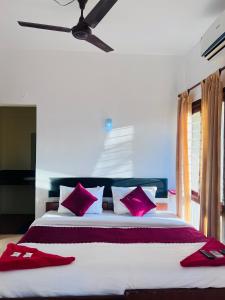 a bedroom with a large bed with red pillows at Hotel Sunday - Townhouse Club Airport Trivandrum in Trivandrum