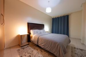 a bedroom with a bed and a blue curtain at Appartement en résidence avec piscine in Agadir +22 photos