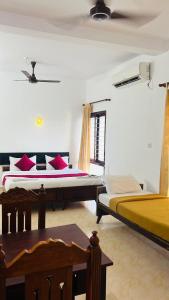 a bedroom with two beds with red pillows at Hotel Sunday - Townhouse Club Airport Trivandrum in Trivandrum