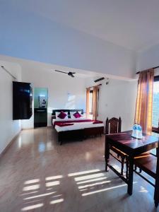 a living room with a bed and a table at Hotel Sunday - Townhouse Club Airport Trivandrum in Trivandrum