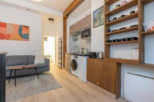 een woonkamer met een bank en een wasmachine bij Charming two bedroom Wagram 17th in Parijs