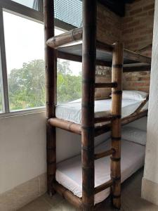 a wooden bunk bed in a room with a window at Villa tikuna in Mariquita