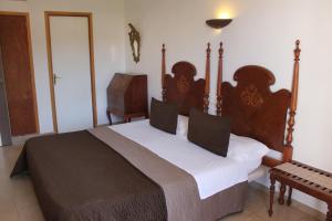een slaapkamer met een groot bed met een houten hoofdeinde bij Hostal Catalina Vera in Port d’Andratx