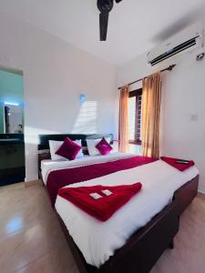 a bedroom with two beds with red and white pillows at Hotel Sunday - Townhouse Club Airport Trivandrum in Trivandrum