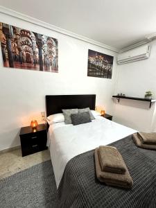 1 dormitorio con 2 camas y toallas. en DS Apartamento Mezquita con cochera, en Córdoba