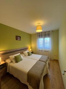 1 dormitorio con 2 camas y paredes verdes en El Mirador de Segovia, en Basardilla