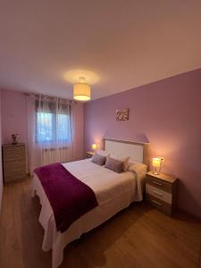1 dormitorio con 1 cama grande, 2 mesitas de noche y 2 lámparas en El Mirador de Segovia, en Basardilla
