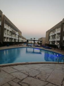 a large swimming pool in front of two buildings at Cecelia Resort Hurghada in Hurghada