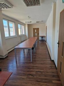 een lege kamer met een grote houten tafel bij HOSTEL PARK-Dobraszczecińska in Szczecińska