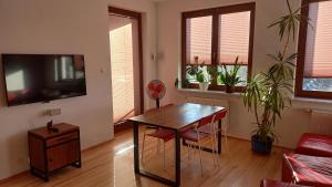 a living room with a table and a tv at Bobrovia Apartment in Warsaw