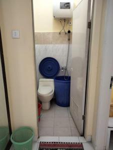 un piccolo bagno con servizi igienici e vasca blu di Villa Highland No 8 Berastagi View a Berastagi
