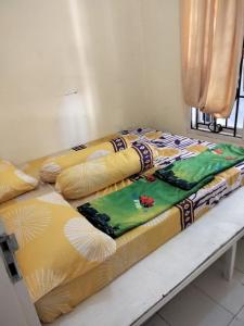 a bed with a blanket on top of it at Villa Highland No 8 Berastagi View in Berastagi +10 photos