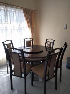 uma mesa de jantar com 4 cadeiras e uma janela em Villa Highland No 8 Berastagi View em Berastagi