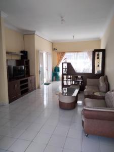 a large living room with a couch and a tv at Villa Highland No 8 Berastagi View in Berastagi +12 photos