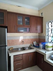 a kitchen with wooden cabinets and a stainless steel refrigerator at Villa Highland No 8 Berastagi View in Berastagi