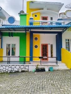 una casa colorida con una calle adoquinada delante en Villa Highland No 8 Berastagi View, en Berastagi
