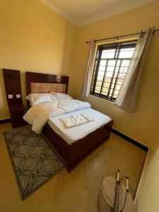 Schlafzimmer mit einem Bett und einem Fenster in der Unterkunft Getaway bnb - Njombe in Njombe